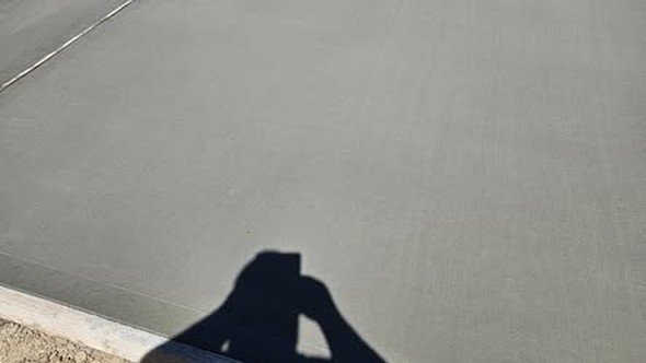 A large concrete pad formed, poured, and finished smooth by Level Headed Construction, with a clean control joint