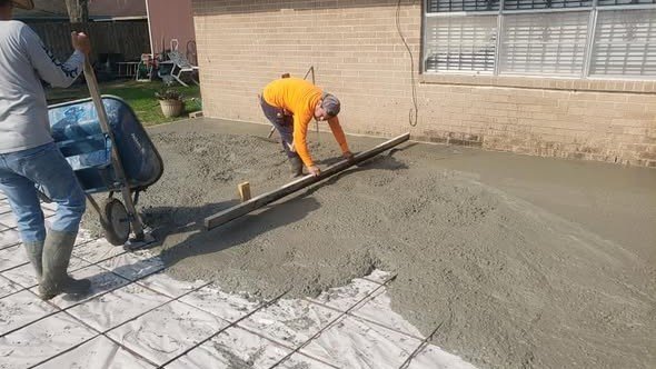 A Level Headed Construction crew placing and screeding a fresh concrete pad over reinforcing mesh in the Lake Houston area