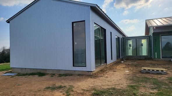 A modern metal-clad custom home framed and dried-in by Level Headed Construction with large black-framed sliding-glass doors