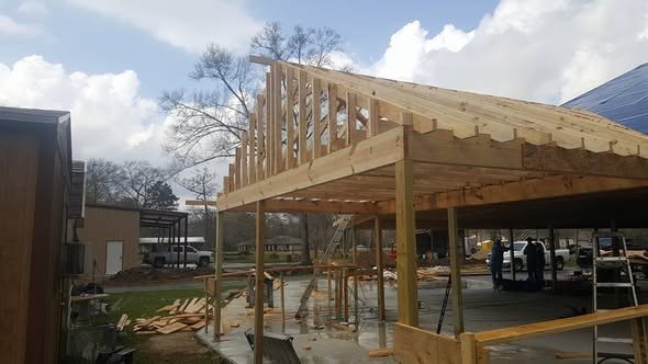Heavy timber gable framing for a patio cover under construction over a concrete patio in the Lake Houston area
