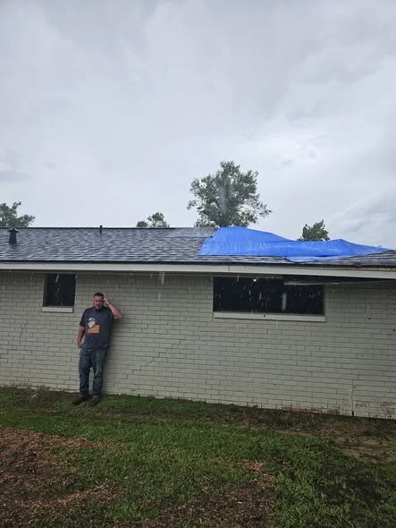 A storm-damaged roof tarped by Level Headed Construction while an insurance claim is documented
