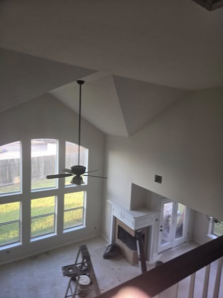 A two-story great room with an arched window wall, opened up and refinished by Level Headed Construction during a whole-home remodel in the Lake Houston area